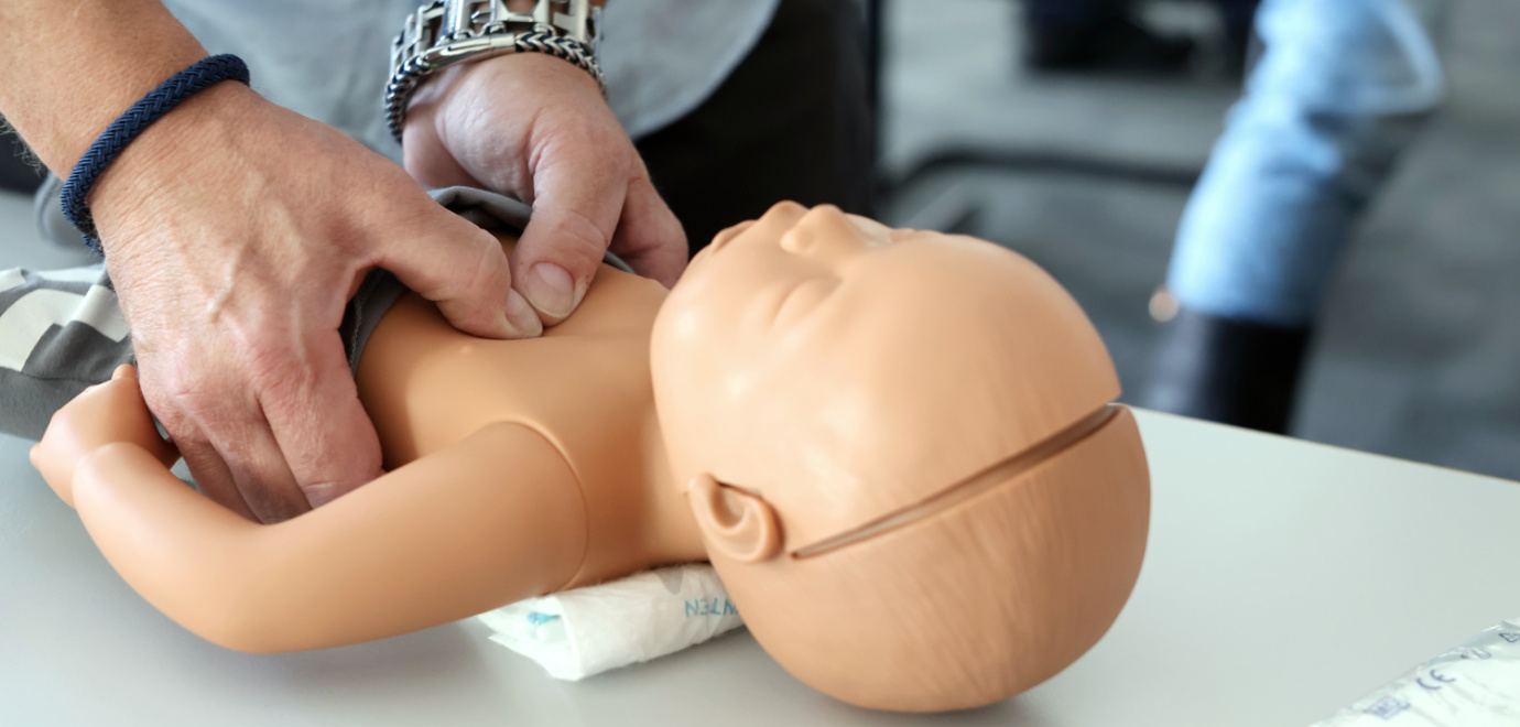 Übung der Wiederbelebung eines Kleinkindes an einer Puppe