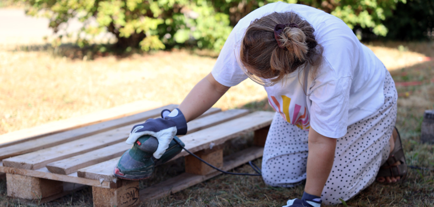 Jugendliche schleifen im Sophienpflegeprojekt Paletten ab